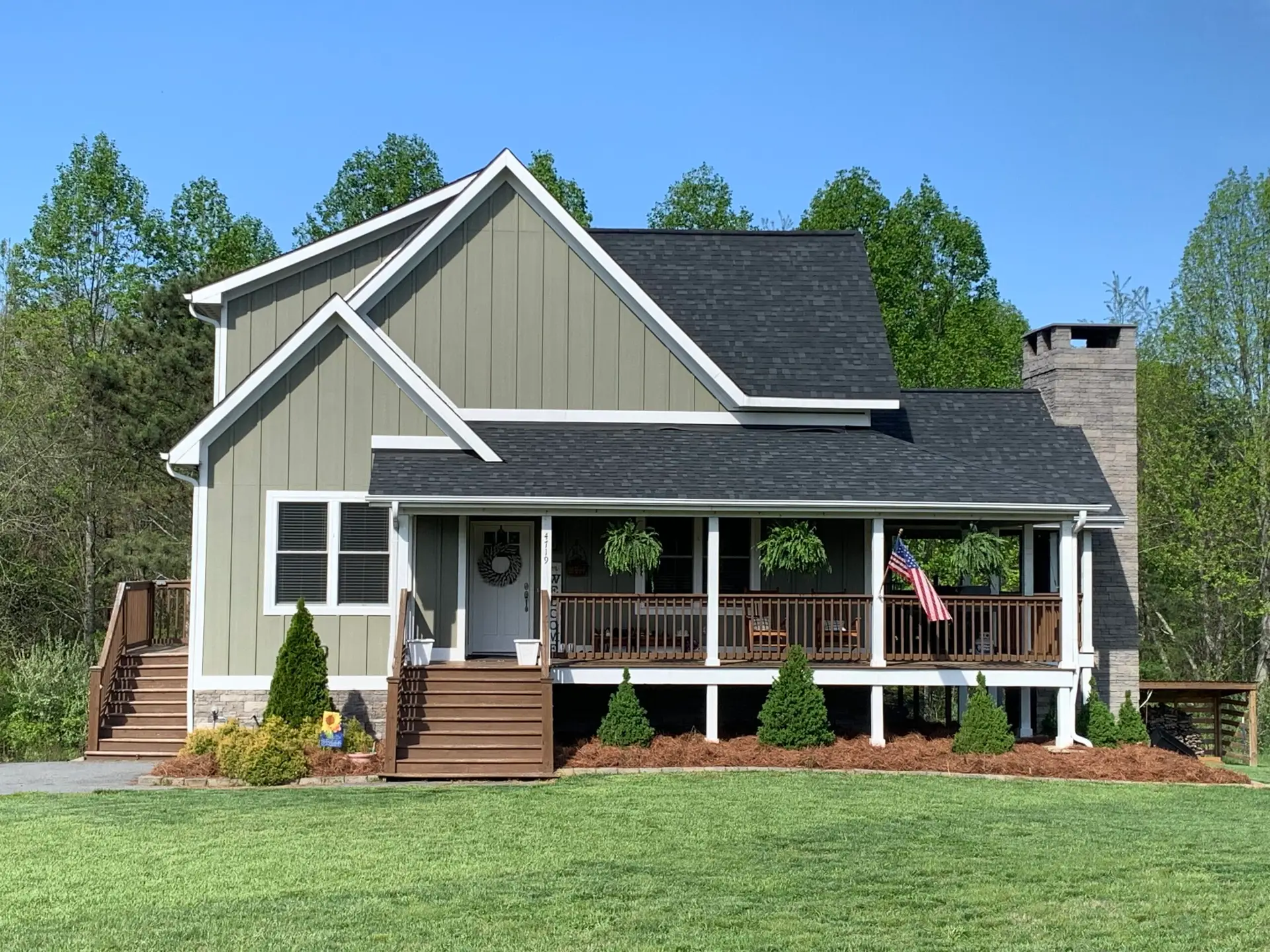New Construction Custom Home, green exterior siding house, white double hung windows, composite deck, black shingles