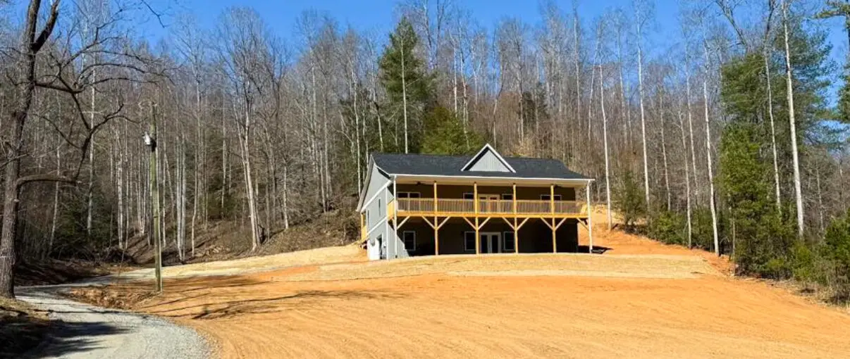 new construction home modern farmhouse with grey exterior board and batten siding, black shingles