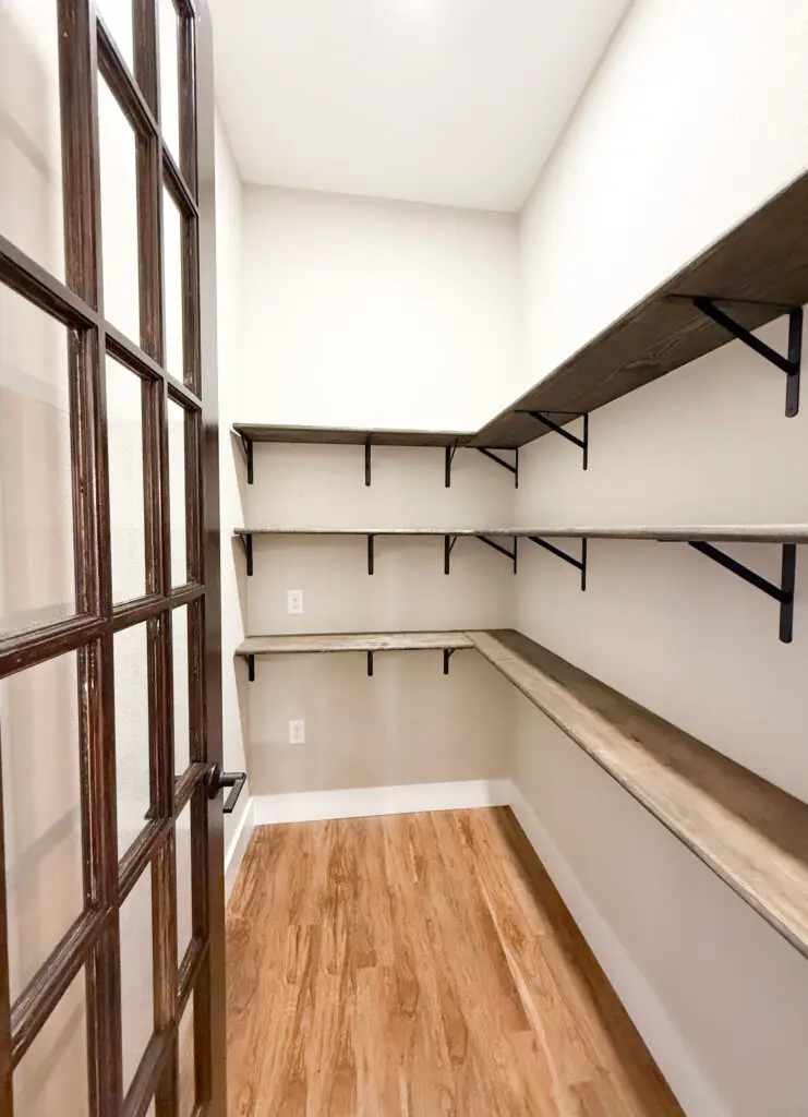 new construction bedroom with LVP flooring, coffered ceilings, gray painted walls