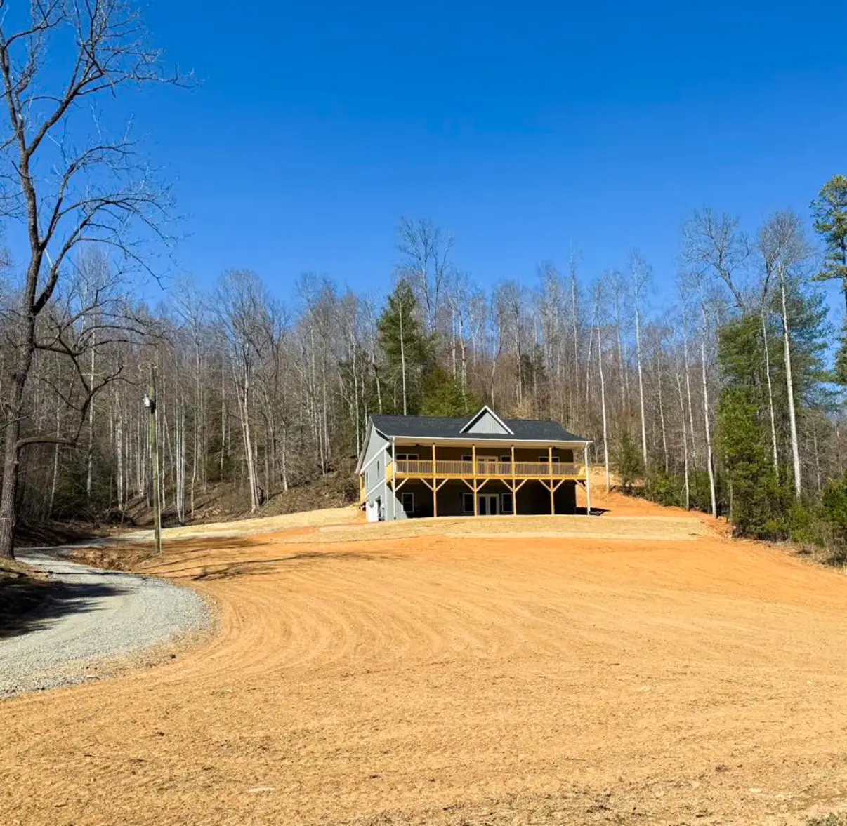 new construction home modern farmhouse with grey exterior board and batten siding, black shingles