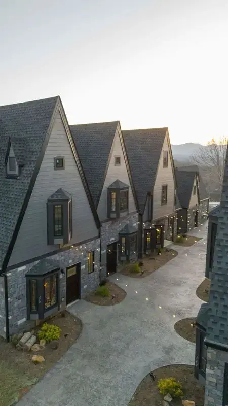 new construction build village castle style with stone exterior gray siding gray roofing