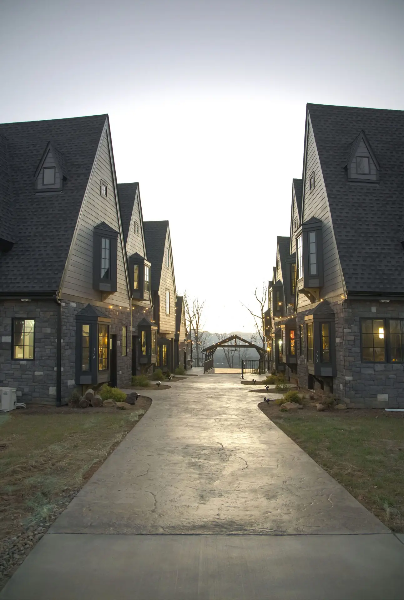 new construction build village castle style with stone exterior gray siding gray roofing