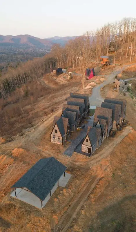 new construction build village castle style with stone exterior gray siding gray roofing