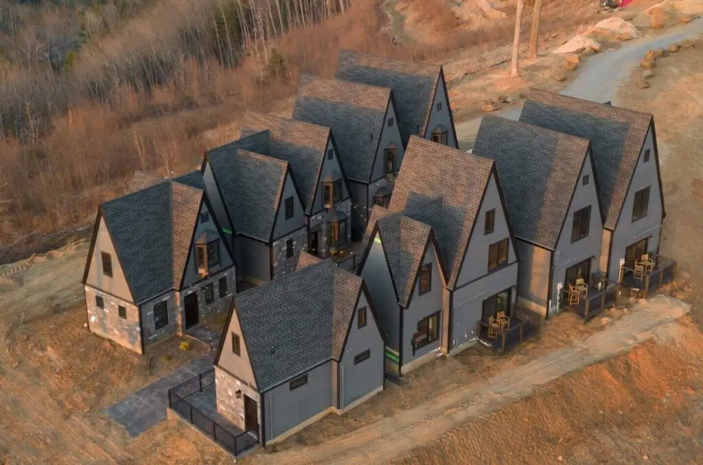 new construction build village castle style with stone exterior gray siding gray roofing