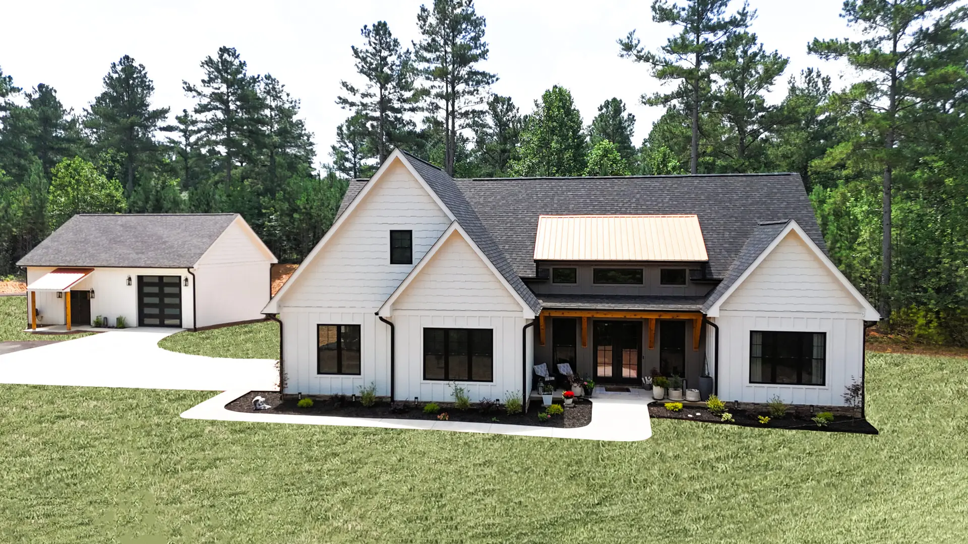 Modern white new construction farmhouse with detached garage and green grass front yard