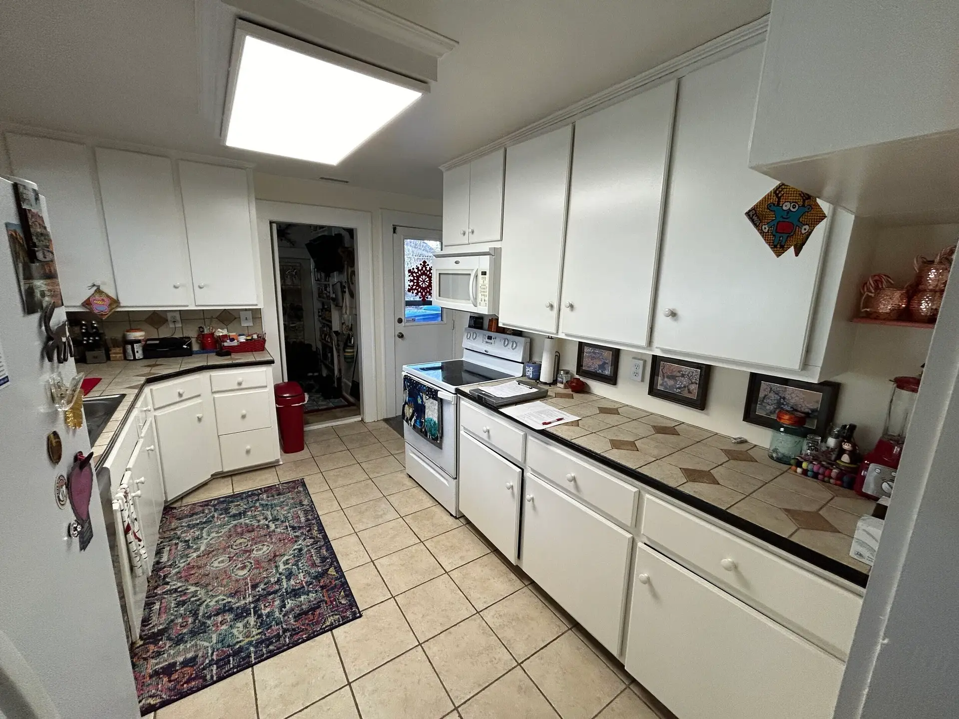kitchen with white cabinets, tile countertops