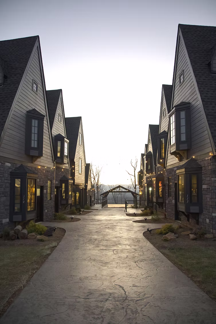 new construction build village castle style with stone exterior gray siding gray roofing