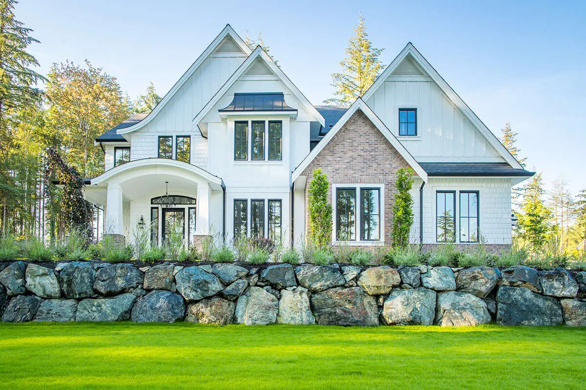 New Construction European-style home with elegant rooflines and mixed siding including stucco, stone, and wood accents